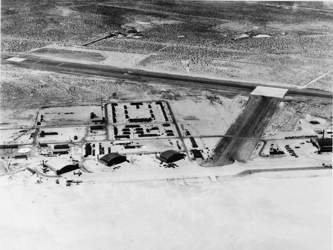 Oblique aerial view of North Base at Edwards Air Force Base, California, with the edge of Rogers Dry Lake in the foreground (about 1952).