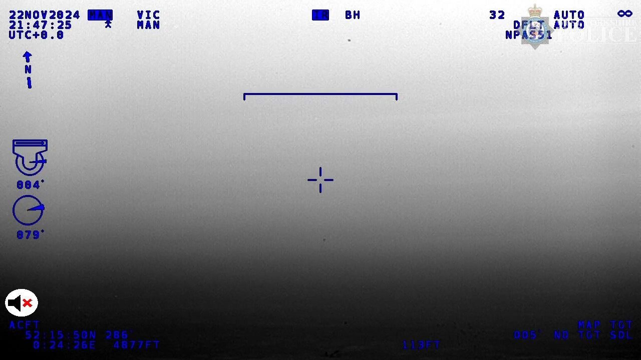Single infrared frame from the NPAS 51 FLIR at 21:47:25, the moment linked to the near-miss; a small dark point near the top of the frame, turret azimuth 079 deg relative. 2024-11-22 21:47:25 UTC, Near RAF Lakenheath, Suffolk, UK (NPAS 51 position 52:15:50N 0:24:26E, 4877 ft). Status: Authentic official frame; UK Airprox Board attributes the encounter to an F-15 (see previous item). Note: Object is a few pixels; identification rests on the Airprox Board timeline and ADS-B, not on the image.