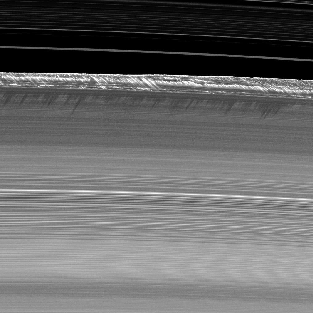 Vertical structures up to about 2.5 km tall rise from the edge of Saturn's B ring and cast long shadows, two weeks before the August 2009 equinox (Cassini, PIA11668).