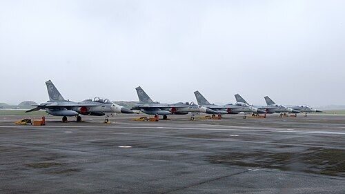 Context: five F-CK-1 (IDF) fighters of the 427th Wing on the apron at Ching Chuan Kang air base, Taichung, 26 Nov 2016. On 8 Sep 2026 an unidentified drone closed the base and eight IDF fighters on night training diverted to Hsinchu.