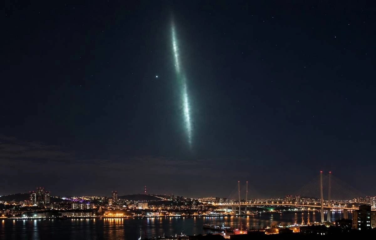 The blue-green glowing band over Vladivostok on the evening of 27 October 2026, above the Golden Bridge.