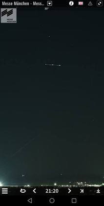Screenshot of the Messe München Panomax 360-degree webcam posted as a "clear image of something over the airport". 2025-10-03 ~21:20 local, Messe München webcam (Riem), Munich, Germany. Status: Not verified. Note: The webcam is about 25 km from the airport. Metabunk: this 21:20 streak is a Turkish Airlines 737 (TC-JVN); other Panomax "drones" that night were a police helicopter. Archive: https://messe-muenchen.panomax.com?t=2025-10-03+21-20-00&r=36&z=270&tl=1028
