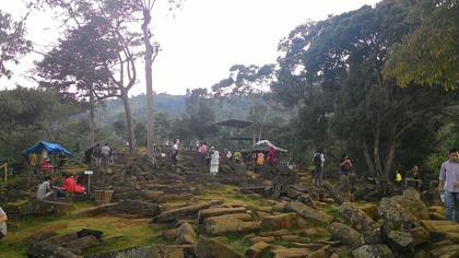 Visitors on the fourth and third terraces of Gunung Padang, strewn with fallen stone columns (2015).